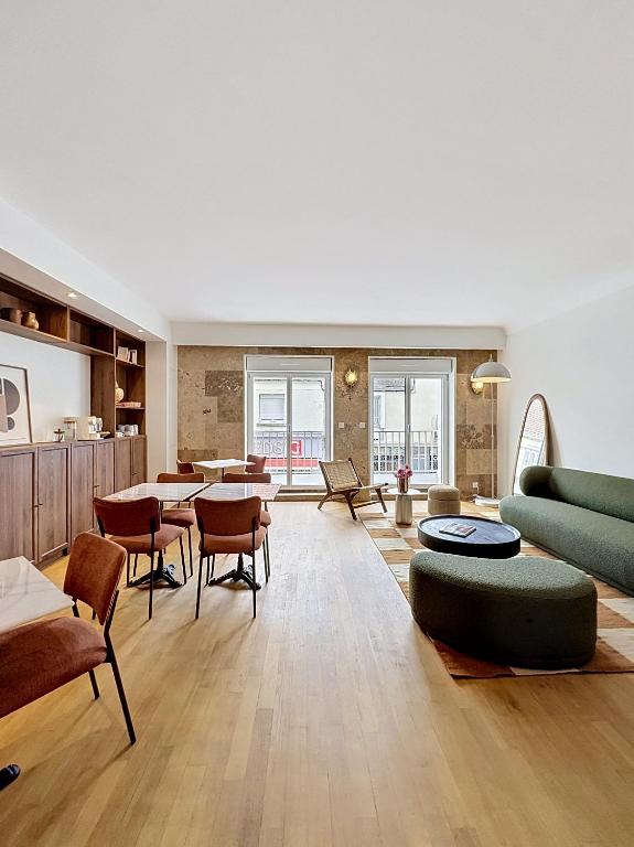 a living room with a couch and tables and chairs at Maison Plage - boutique hôtel in Saint-Brevin-les-Pins