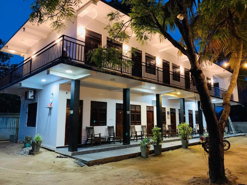a large white building with a balcony on it at Quench Inn in Ampara