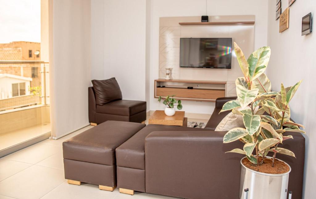 a living room with a brown couch and a chair at Torre Ginebra luxury laureles in Medellín