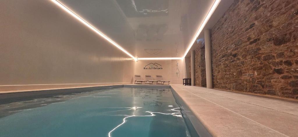 a swimming pool in a room with a brick wall at Klass Loft Kemperle in Quimperlé