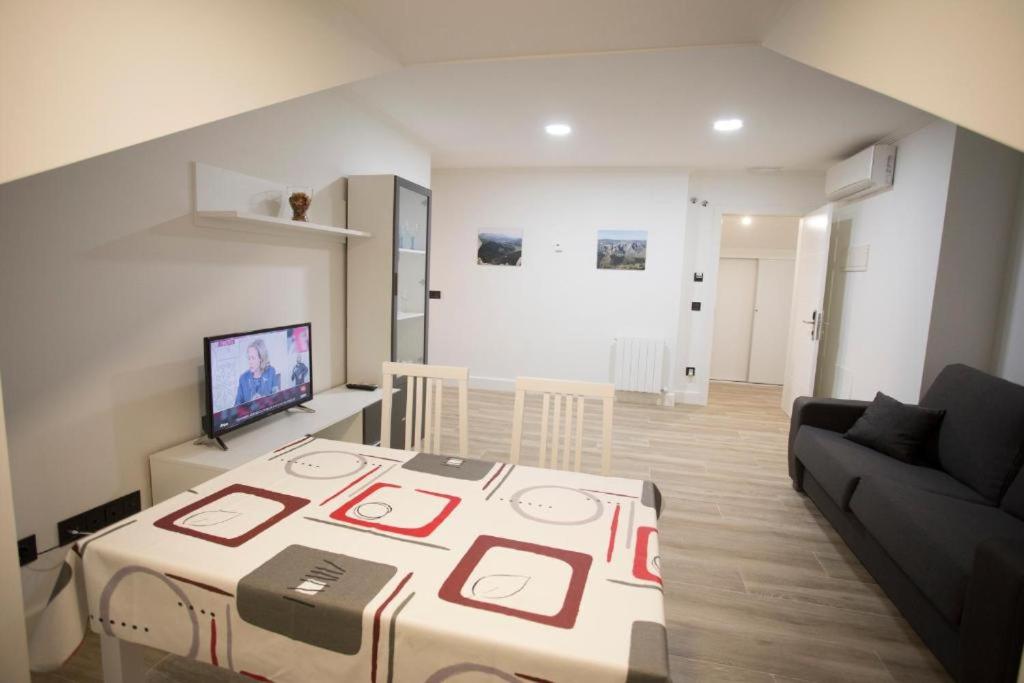 a living room with a table and a couch at Apartamentos Canto Encaramado in Gibaja