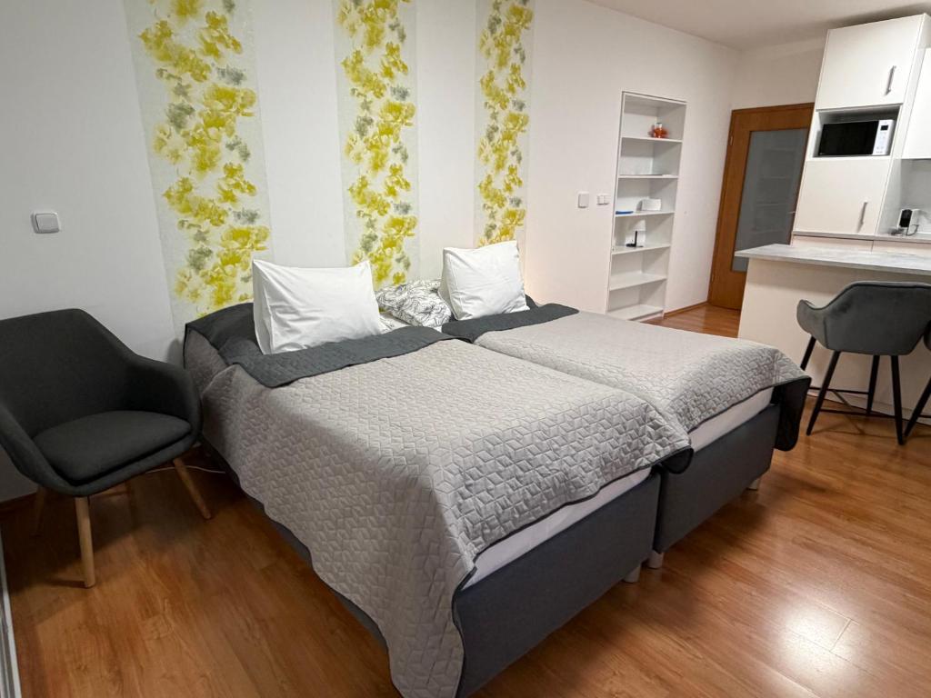 a bedroom with a bed and a chair in it at Apartment Komin in Komín