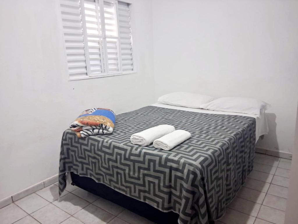 a bedroom with a bed with two towels on it at Hospedagem Aeroporto in Campinas