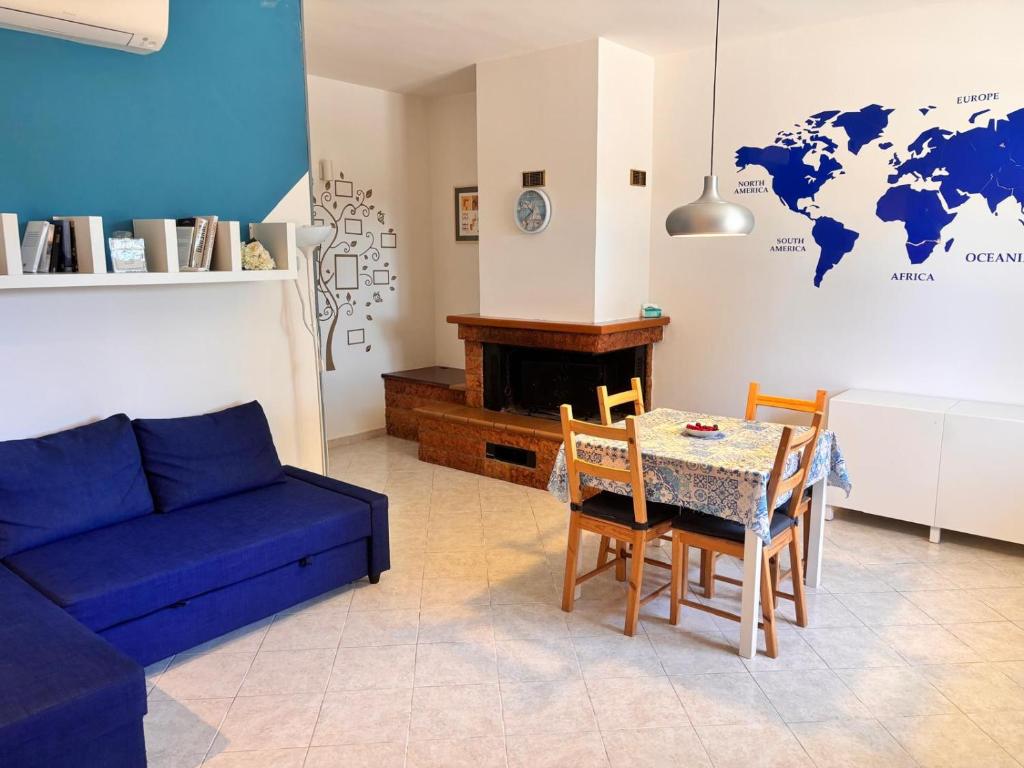 a living room with a table and a blue couch at casa villa degli ulivi in Colonnella