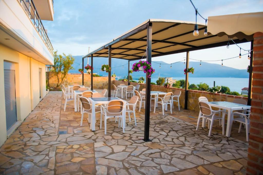 a patio with tables and chairs under a canopy at Seaview Radhime in Vlorë