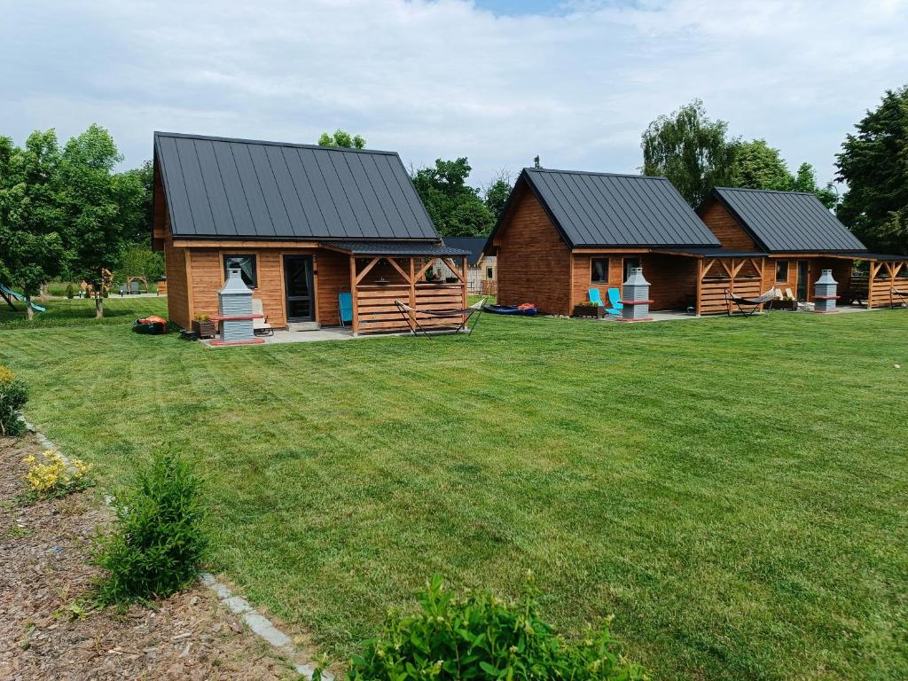 a log cabin with a large yard in front of it at Domki Marianowo in Marianowo