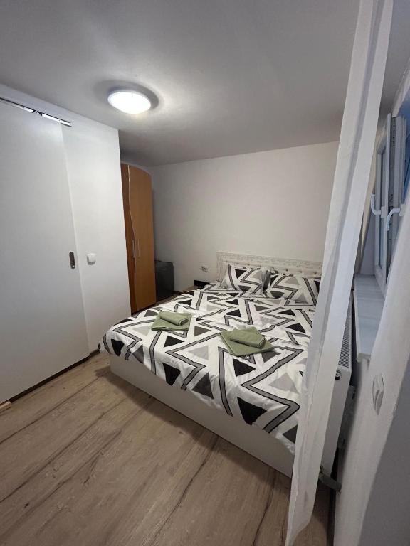 a bedroom with a bed with a black and white comforter at Raisa in Ocna Sibiului