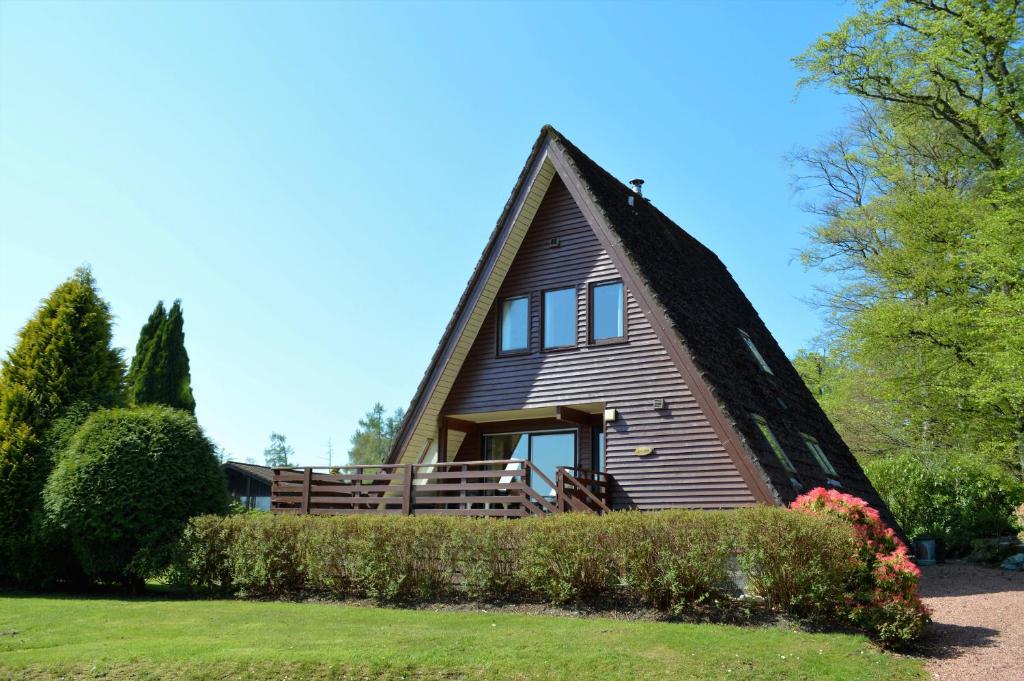 ダヌーンにあるLoch View Lodgeの茅葺き屋根の家