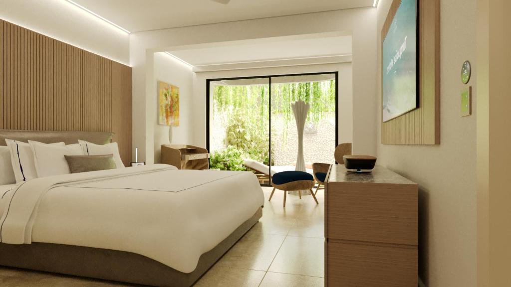 a bedroom with a large white bed and a chair at Blue Monkey Hotel & Beach Club in Saint James
