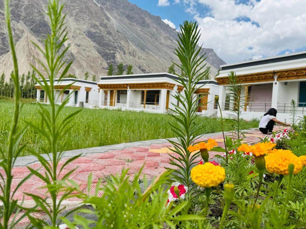 a woman in a garden in front of a building at Arhat Resort in Deskit