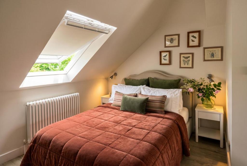 a bedroom with a bed with a red blanket and a window at Beautiful New Forest Hideaway in West Wellow