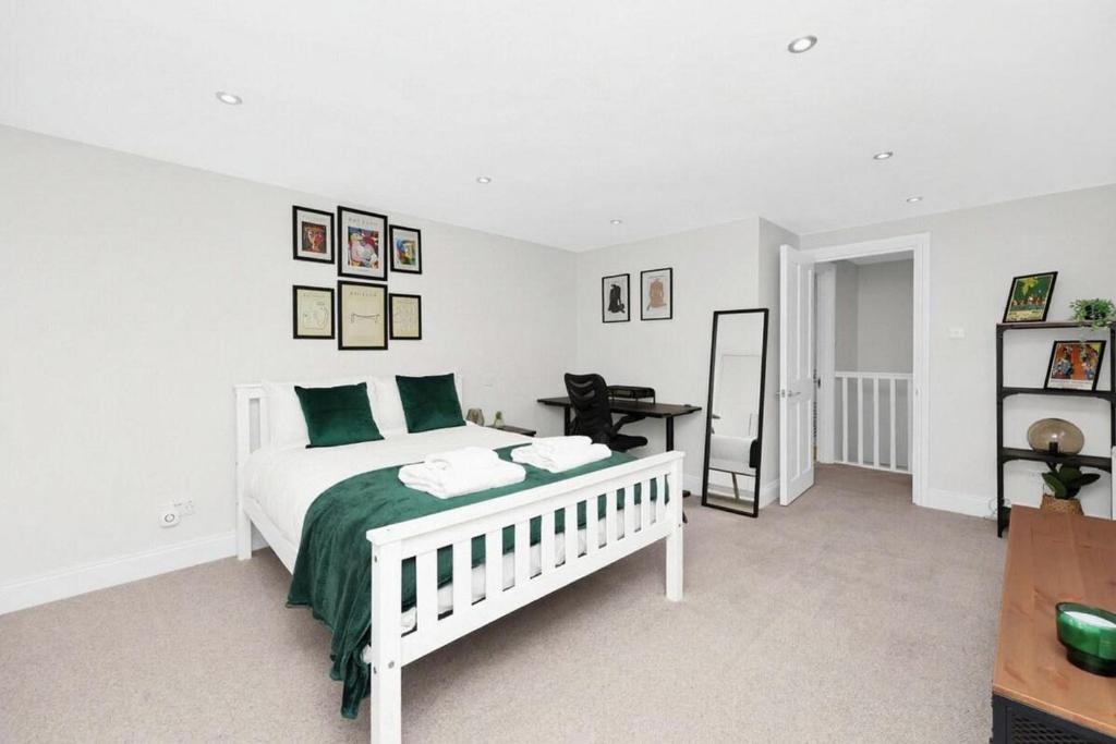 a bedroom with a white bed with green pillows at Flat in Lambeth in London