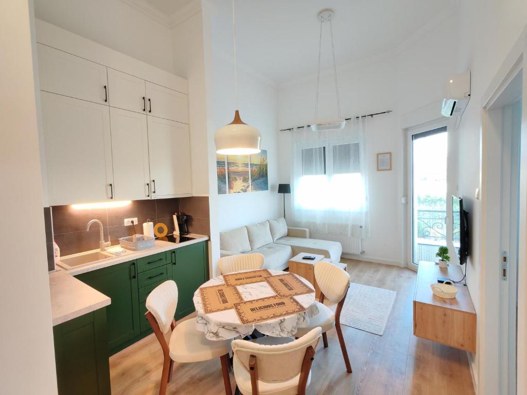 a kitchen and living room with a table and chairs at Apartman Petkov in Palić