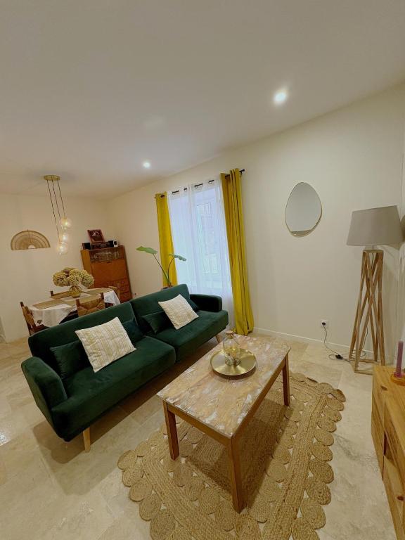 a living room with a green couch and a coffee table at Escapade Lotoise in Cahors