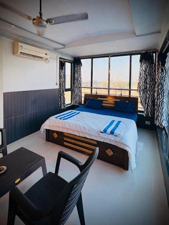 a bedroom with a bed and a table and a chair at Rooftopwaves penthouse in Daman