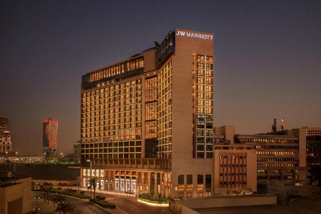 a tall building with a hotel sign on top of it at JW Marriott Hotel Kuwait in Kuwait