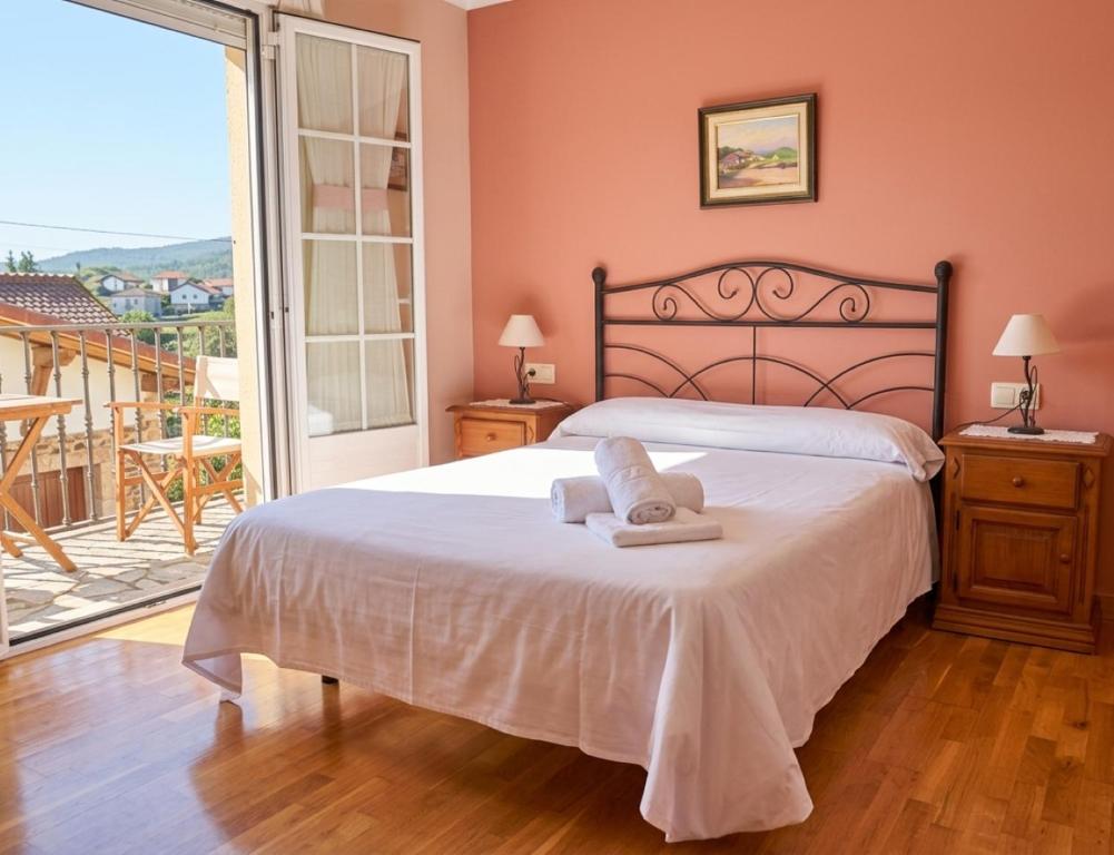 a bedroom with a bed with two towels on it at Casa Raichu - Pilgrim Guesthouse in Obanos