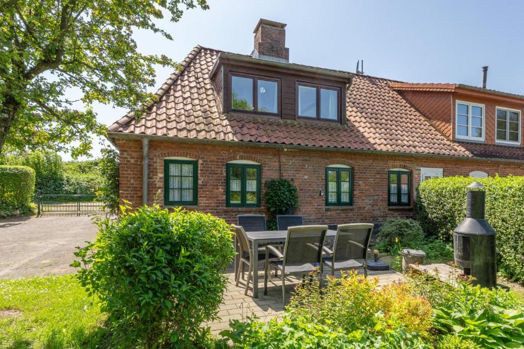 a house with a table and chairs in the yard at Lütt Kate Hemmelmark in Louisenberg