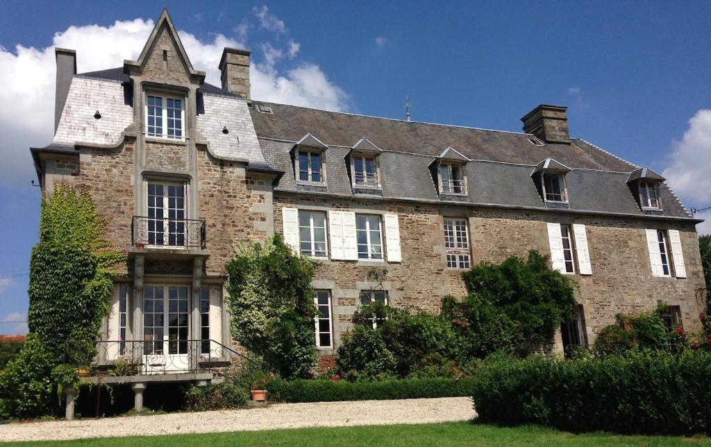 a large brick building with a roof at Château des Boulais Suite in Saint-Martin-le-Bouillant