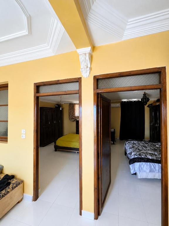 a room with two beds and two sliding doors at Marrakech Family in Marrakesh
