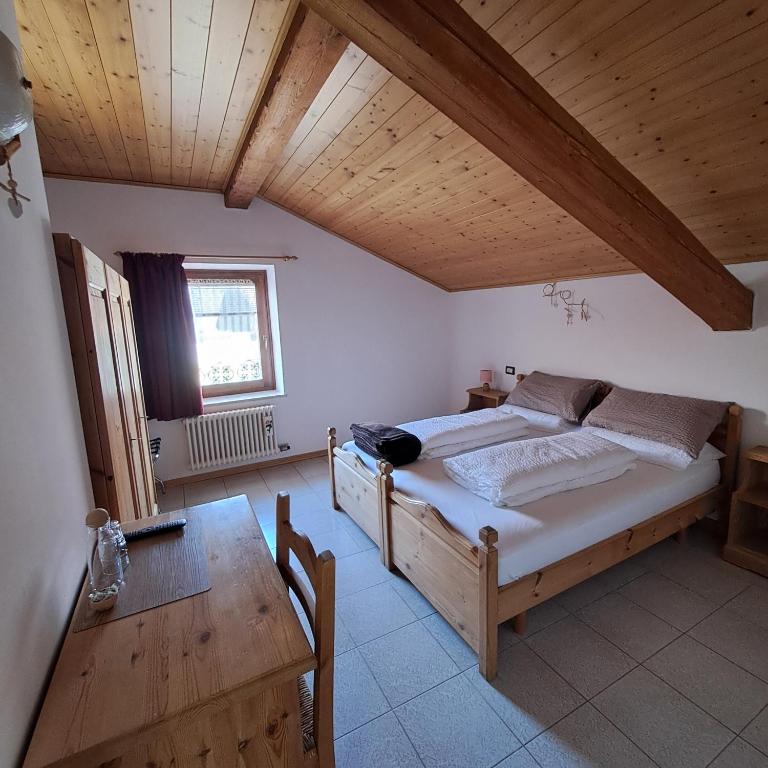a bedroom with a large bed and a wooden ceiling at B&B Casa Zeni in Faedo