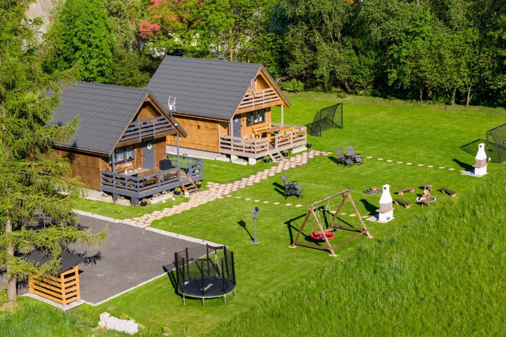 an aerial view of a log cabin with a playground at Domki Skitnica in Mirsk