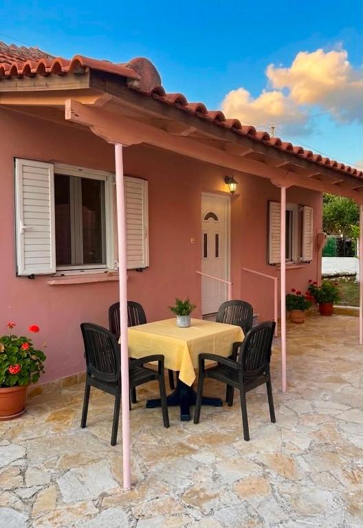 a table and chairs under an umbrella on a patio at ST-Home in Loutsa