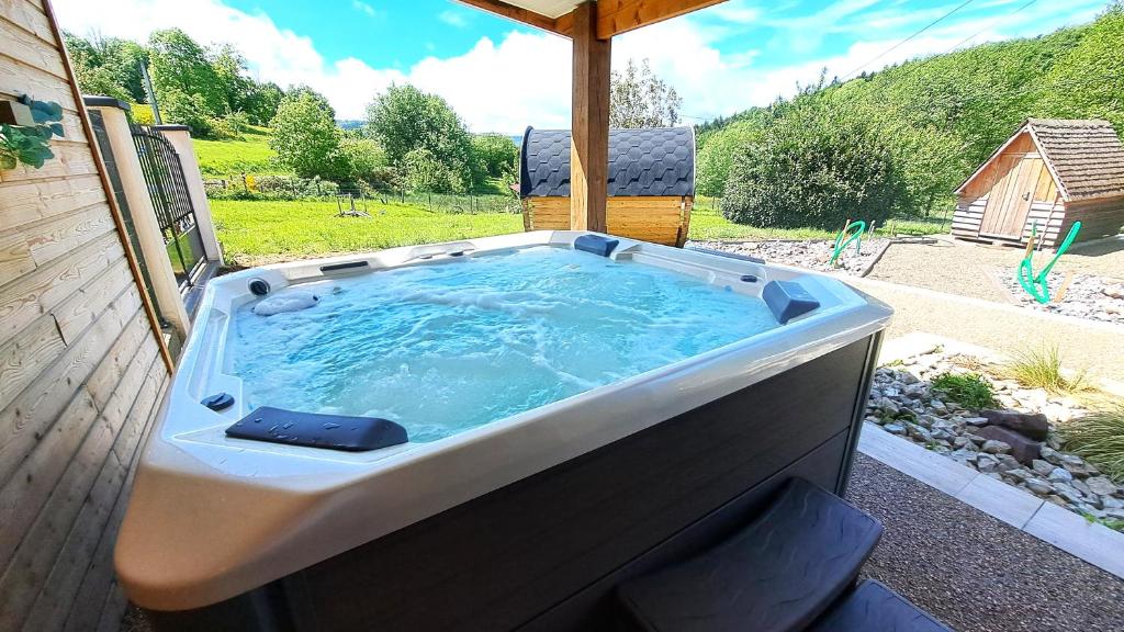 a jacuzzi tub sitting on a patio at Gîte & Spa PRIVÉ "La Colline de Laveline" Proche GÉRARDMER in Laveline-du-Houx