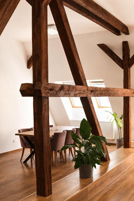 a room with wooden beams and a table with a plant at ATRIO Apartments 3 in Trenčín