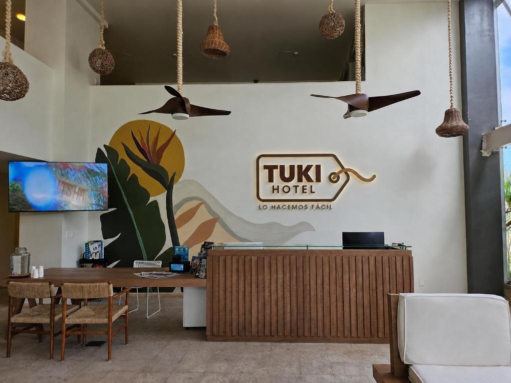 a lobby with a table and birds flying overhead at Hotel Tuki Tulum in Tulum