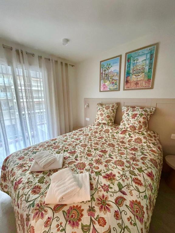 a bedroom with a large bed with a floral bedspread at French Riviera Chic Cocoon - pool, beach, parking in Antibes