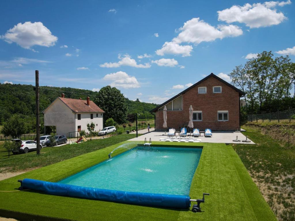 a large swimming pool in the yard of a house at Vikendica Garaski kutak sprat in Arandelovac