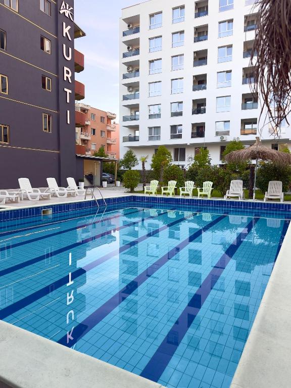 ein großes Schwimmbecken vor einem Gebäude in der Unterkunft KURTI Hotel in Golem