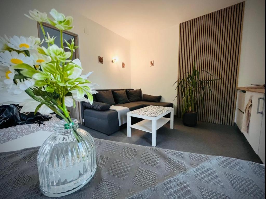 a living room with a vase of flowers on a table at Mozaik Apartman in Kalocsa