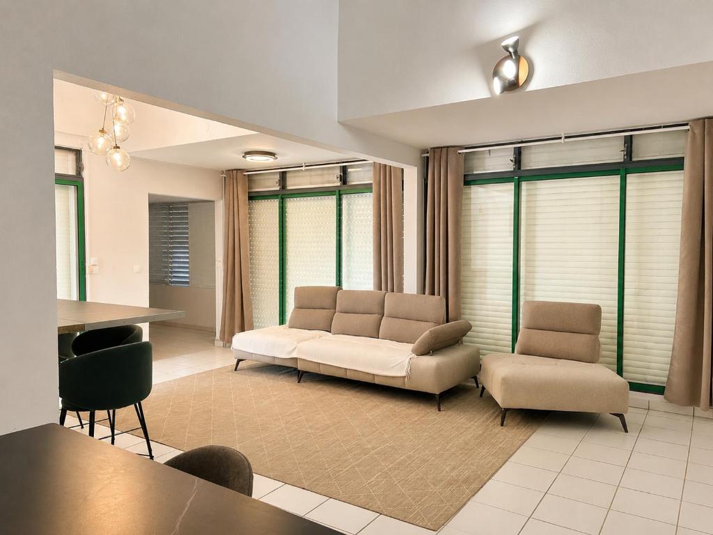 a living room with a couch and a table and chairs at Le Palm Loft in Pointe-à-Pitre