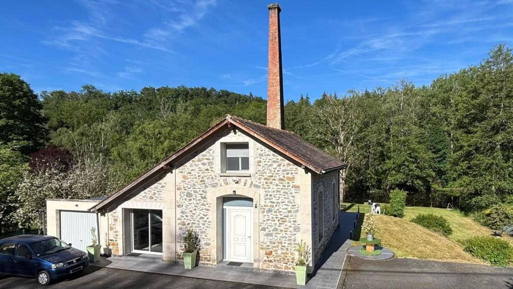 a small brick building with a chimney and a car at Maison charmante en bordure de la Creuse in Glénic