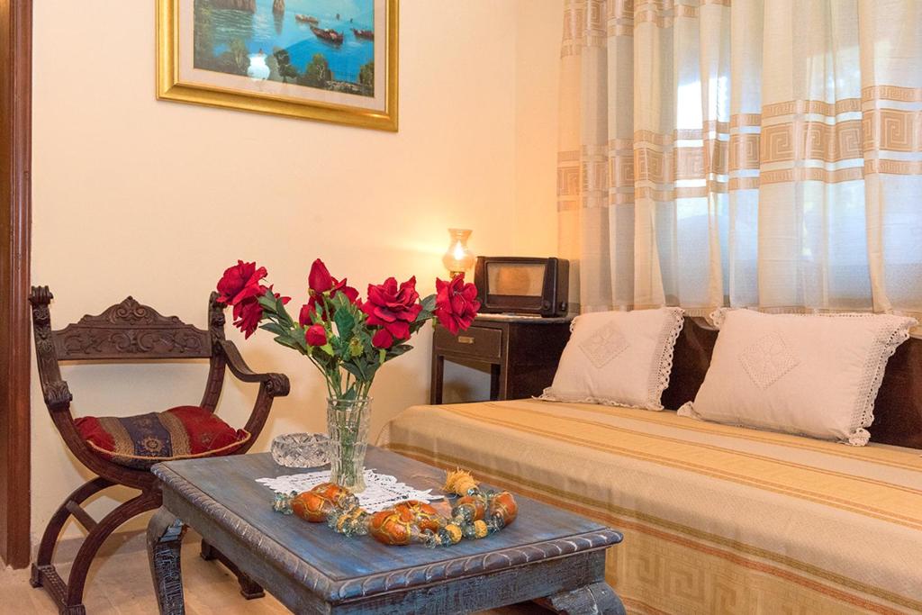 a living room with a vase of red flowers on a table at Villa Feakia in Agios Gordios