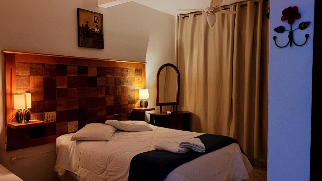 a bedroom with a bed with two towels on it at Pouso Mariazinha in Tiradentes