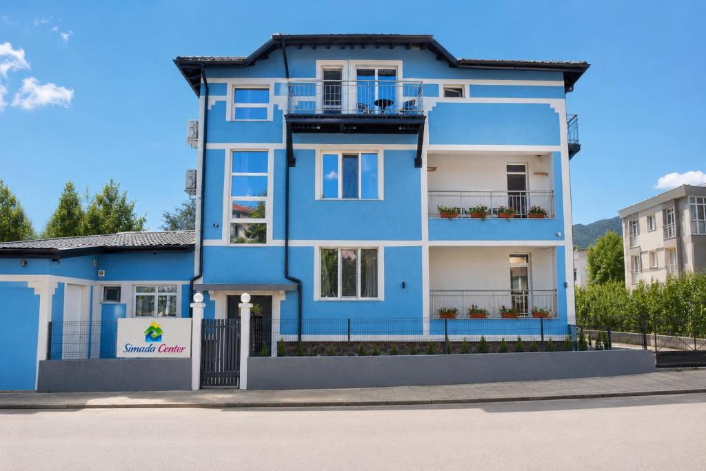 a blue house on a street at Simada Center Guesthouse in Varshets