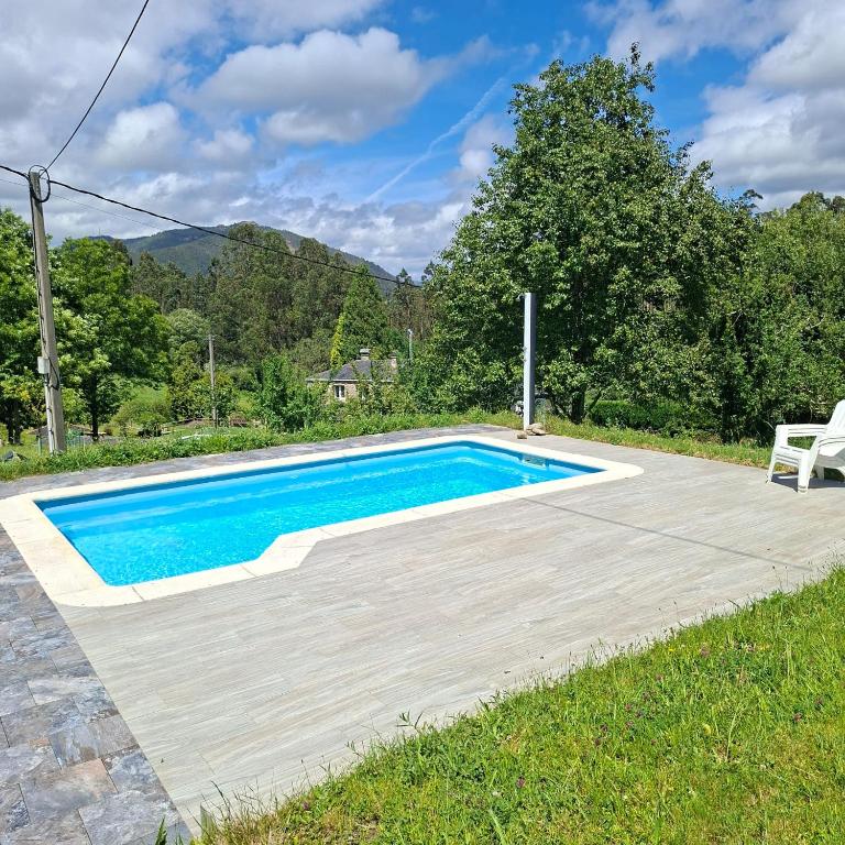 a swimming pool in a yard with a chair next to it at Apartamento en Casa Celia in Orol