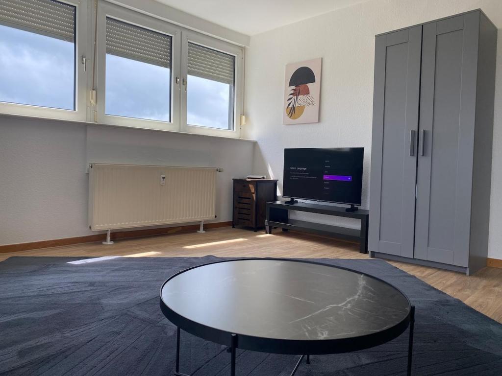 a living room with a coffee table and a tv at Stefans Apartments C - 20 min bis DD Messe und Flughafen inkl Parkplatz in Willich