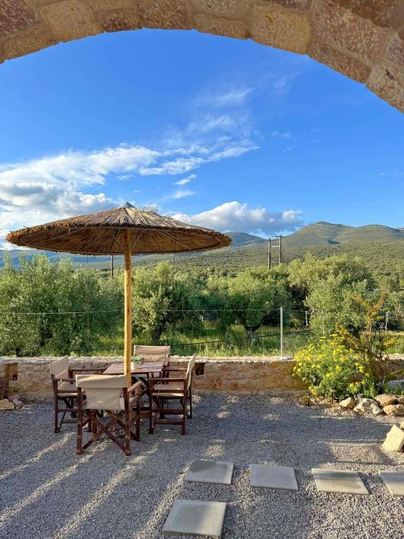 eine Terrasse mit Tisch, Sonnenschirm und Stühlen in der Unterkunft Ckamares in Sikéa