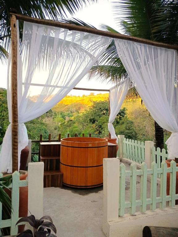 a room with a white fence and a hot tub at Villa Sol hospedaria in Paty do Alferes