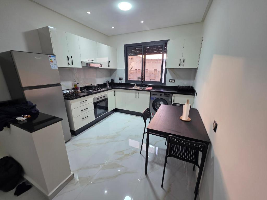 a kitchen with white cabinets and a table with a candle on it at Le calme d'ajdir in Ajdir