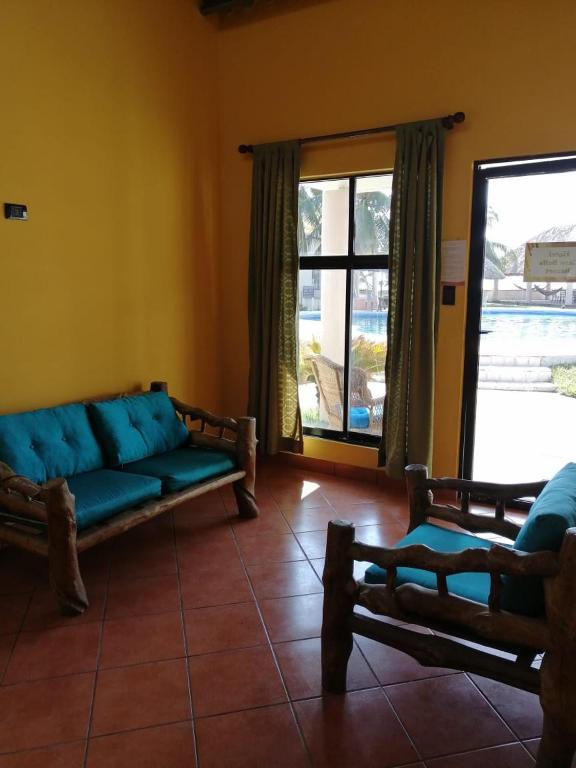a living room with a blue couch and a window at Hotel & Resort Casa Bella in El Hawaii