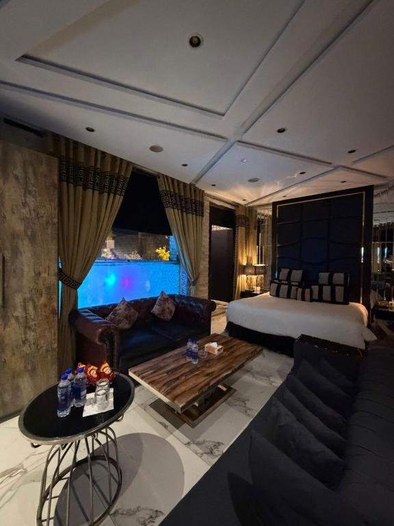 a bedroom with a bed and a couch and a table at Hilton Suites Lahore in Lahore