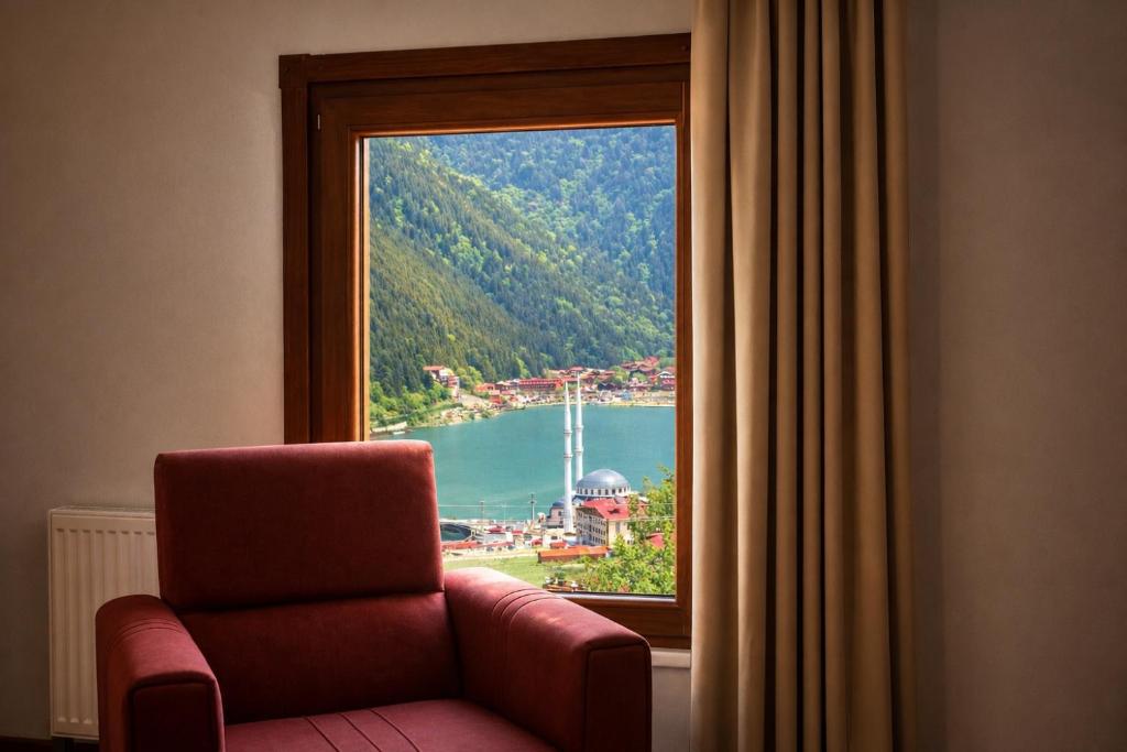 a chair sitting in front of a window with a view at İmera Suite Otel in Uzungöl