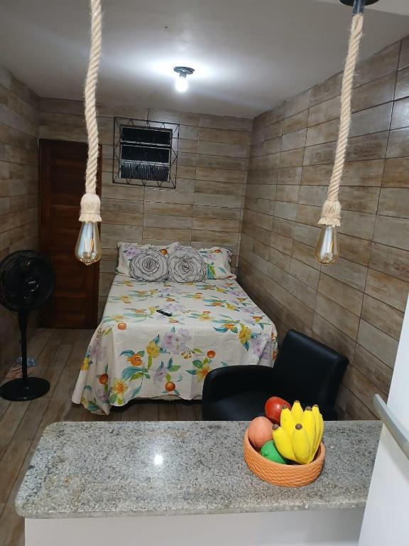 a bedroom with a bed and a bowl of fruit on a counter at Estúdio moderno com cozinha america in Ilhéus
