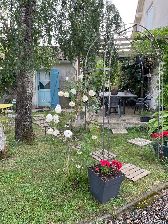 a garden with a arbor and flowers in a yard at STUDIO EN AUVERGNE Le ruisseau in Saint-Priest-Bramefant