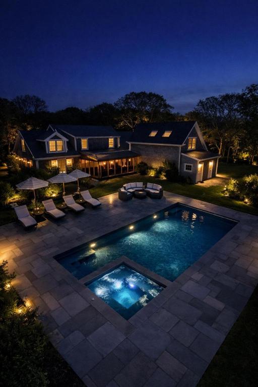 a house with a swimming pool at night at Luxe Chilmark EstatePool, BBQ & Pvt Quansoo Beach in West Tisbury